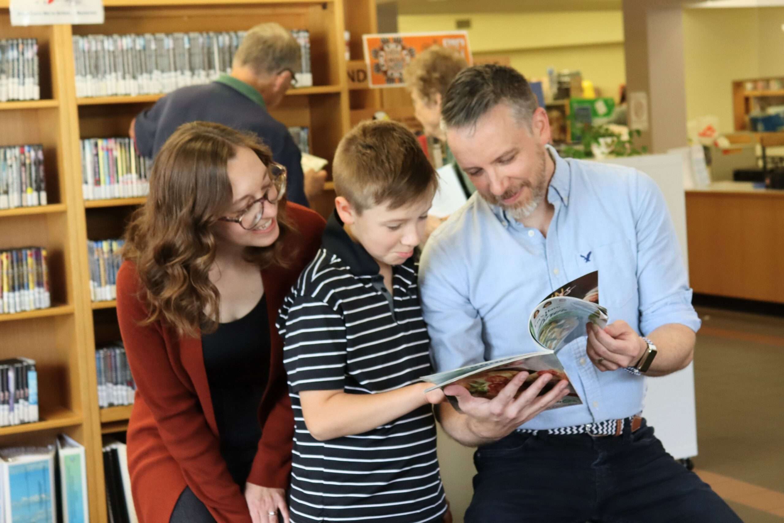 A mother, son, and father read books in the Fonthill Branch.