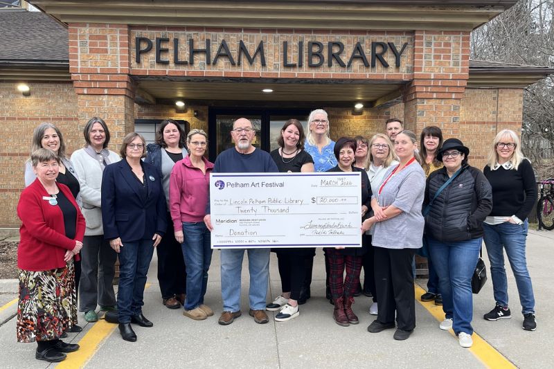 Library board and staff pose alongside members of the Pelham Art Festival presenting an oversized cheque for $20,000 outside the Fonthill Branch.