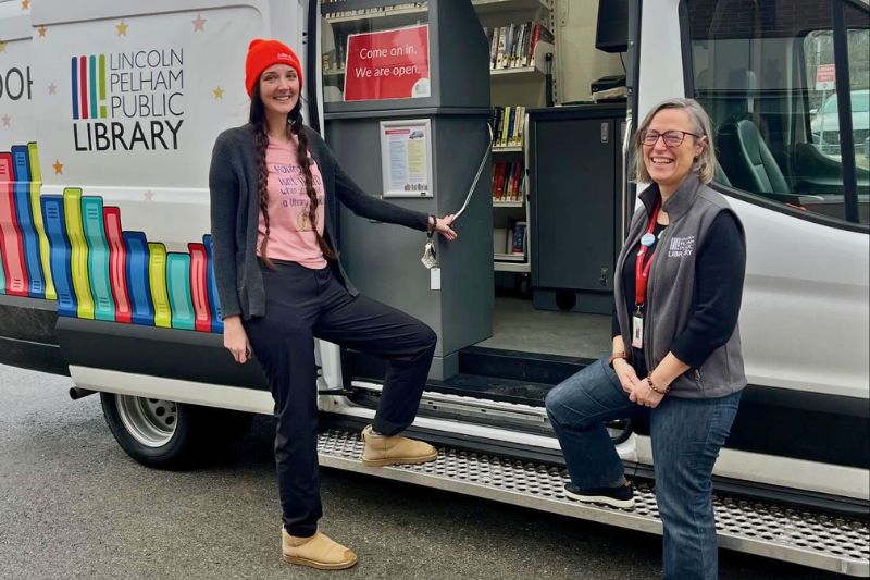 Gabby Lahaie and Susan DiBattista stand in front of the Bookmobile.